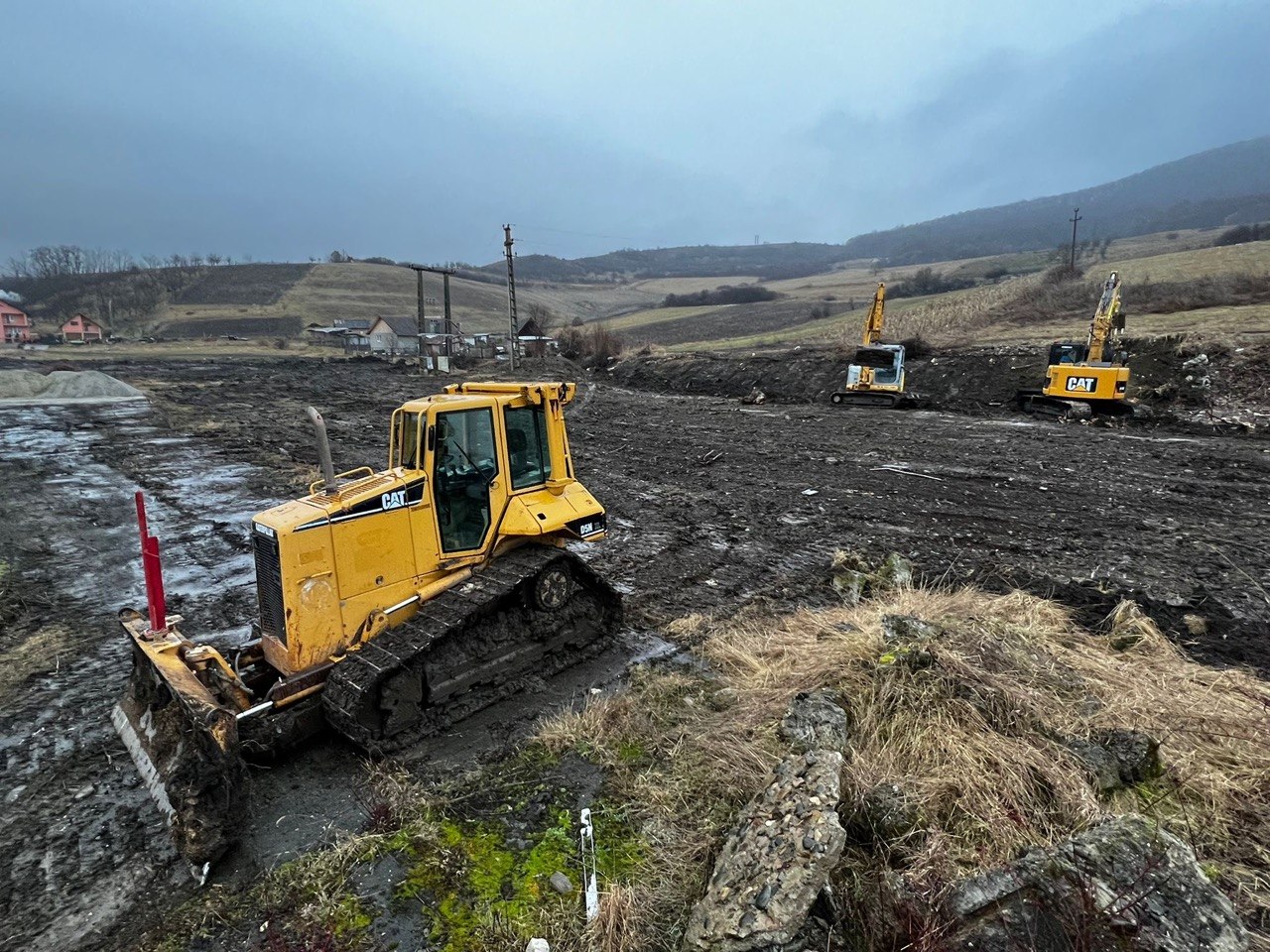 Excavator săpând cotlovan la apus pe șantierul Individual Construct